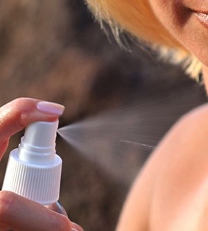 getty rf photo of woman using sunscreen spray